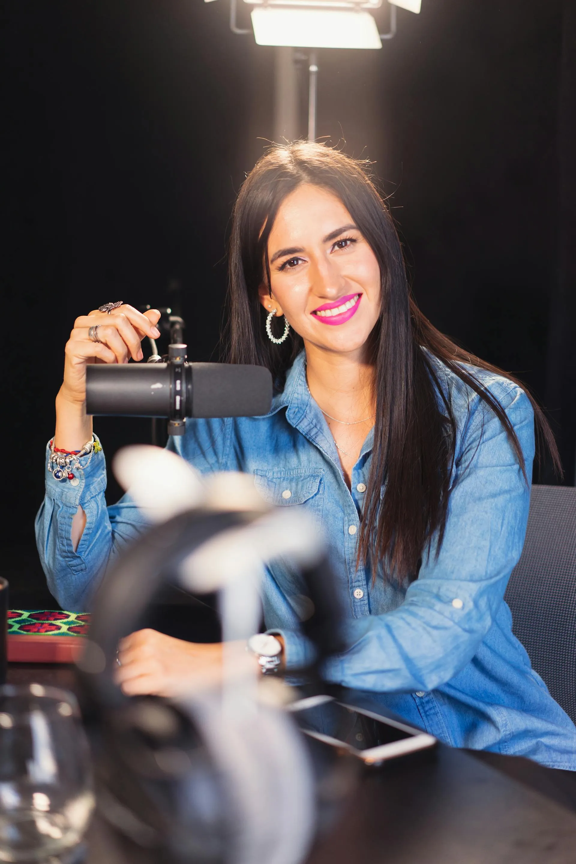 A woman sitting at a table holding a camera.