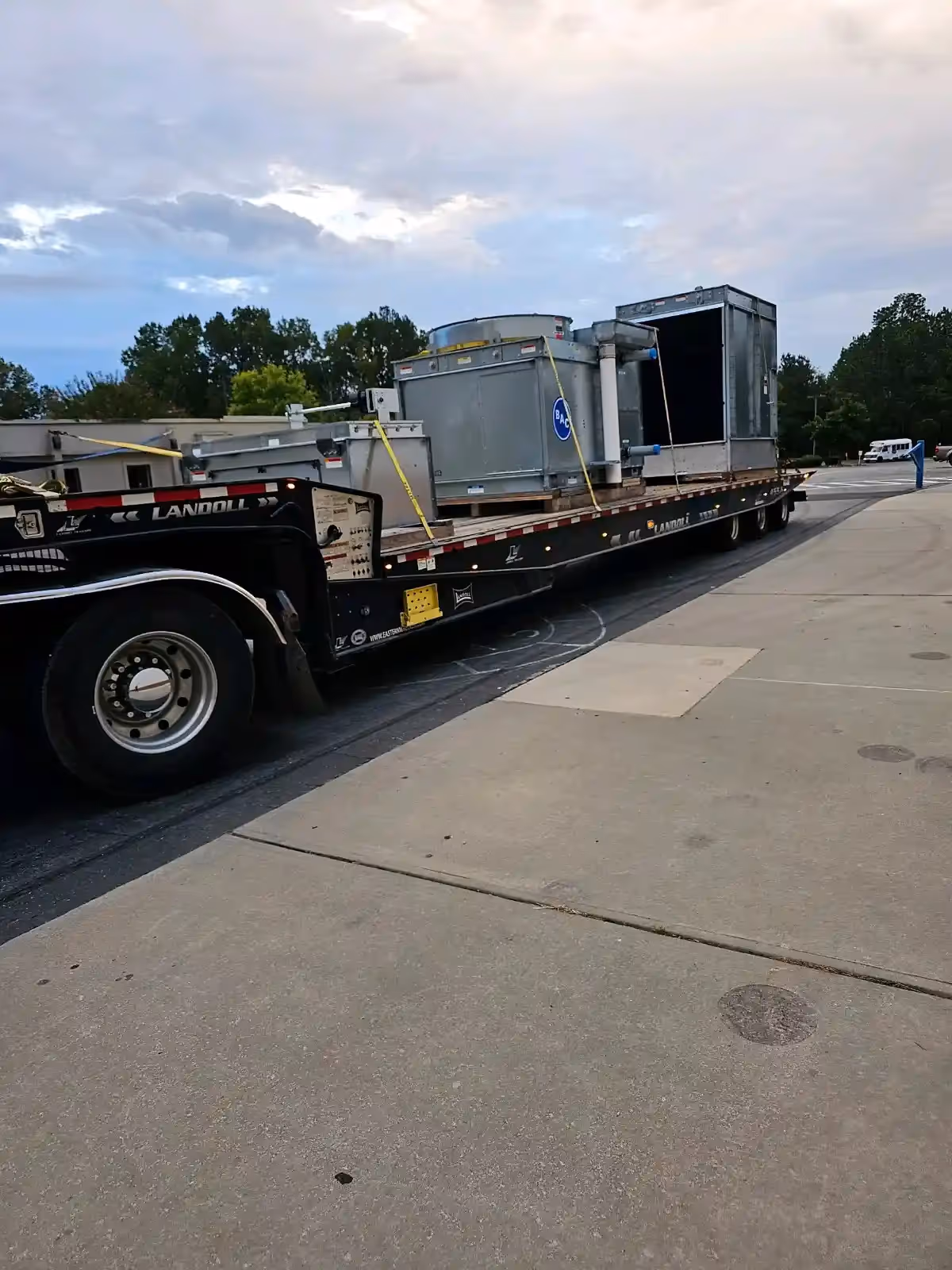 Flatbed truck transporting industrial HVAC equipment in Durham, NC | Temperature Control Services Inc.
