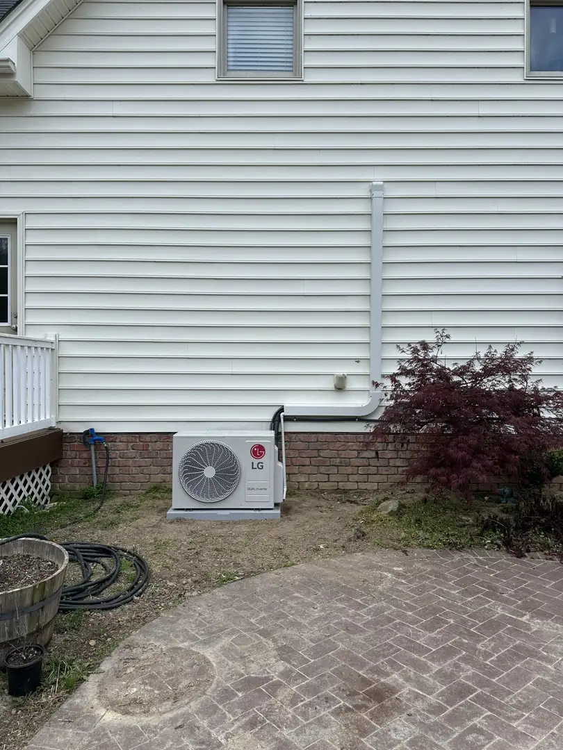 multi-zone outdoor condenser unit sitting on a concrete pad outside a home multi-zone outdoor condenser unit sitting on a concrete pad outside a home
