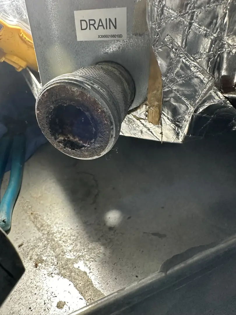 A detailed view of an HVAC evaporator coil showing condensation forming and dripping into a drain pan A detailed view of an HVAC evaporator coil showing condensation forming and dripping into a drain pan
