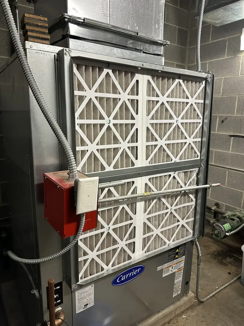 Technician checking an HVAC air filter and showing a clean replacement Technician checking an HVAC air filter and showing a clean replacement