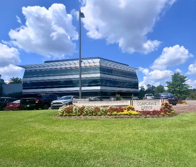 Commercial office building with manicured lawn and seasonal color bed at the entrance sign