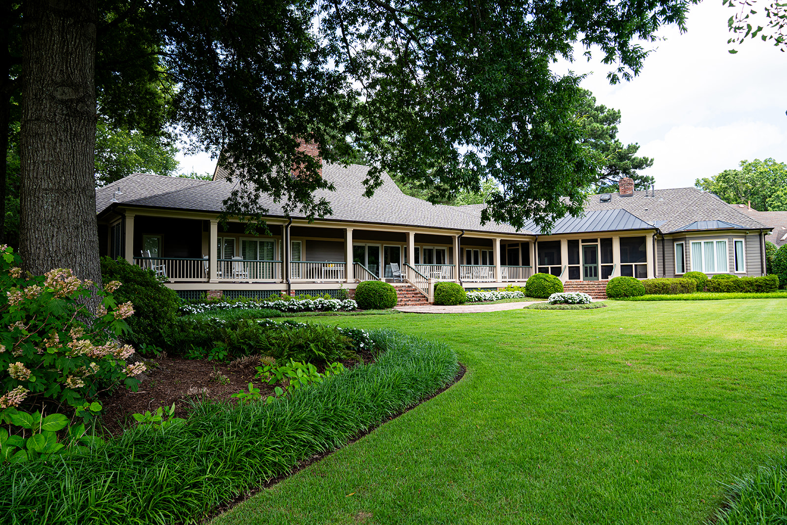 Ranch home with a curved lawn and shaded beds