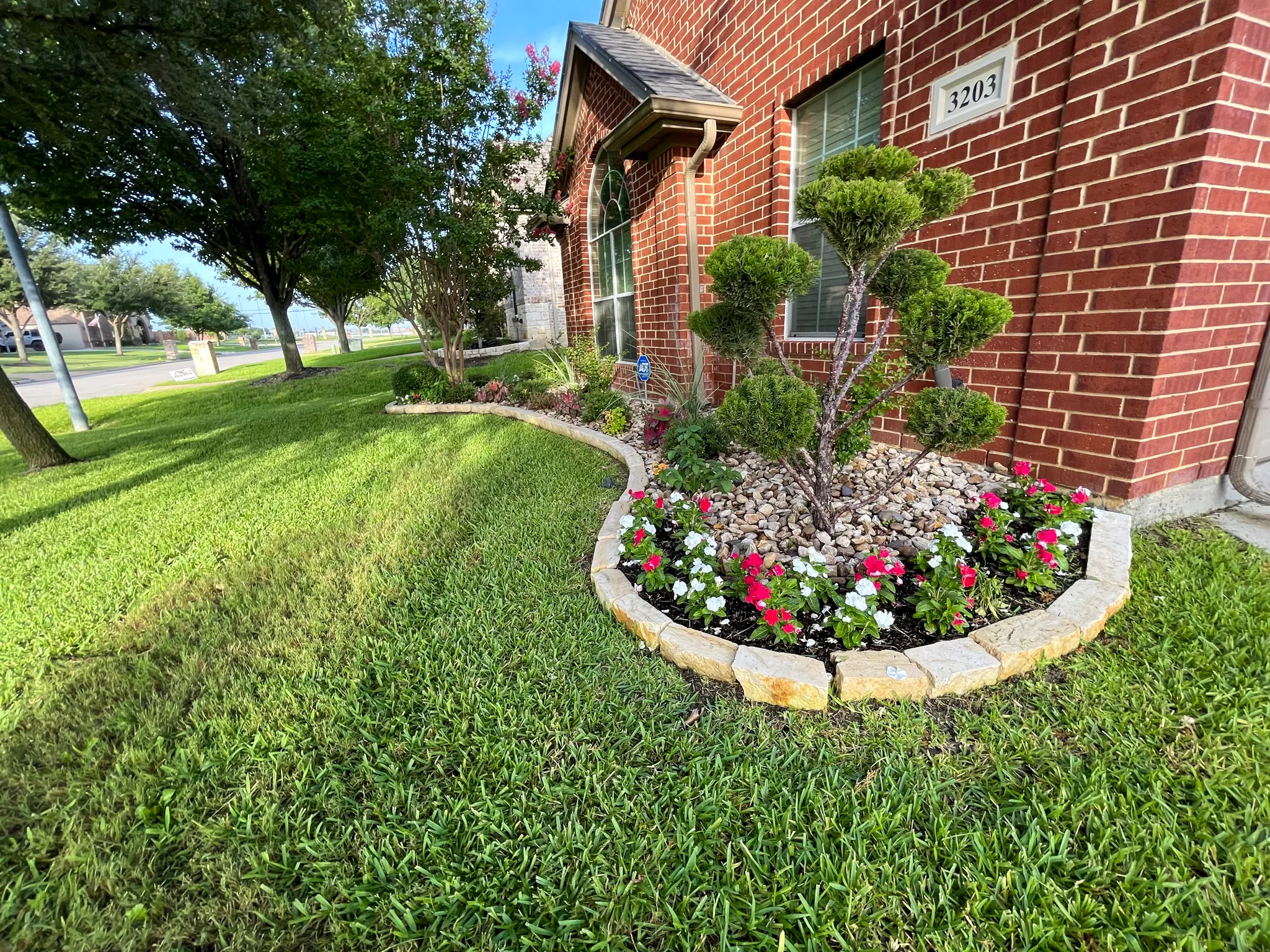 Landscape design service in Mansfield, TX with a mulched flower bed and manicured lawn