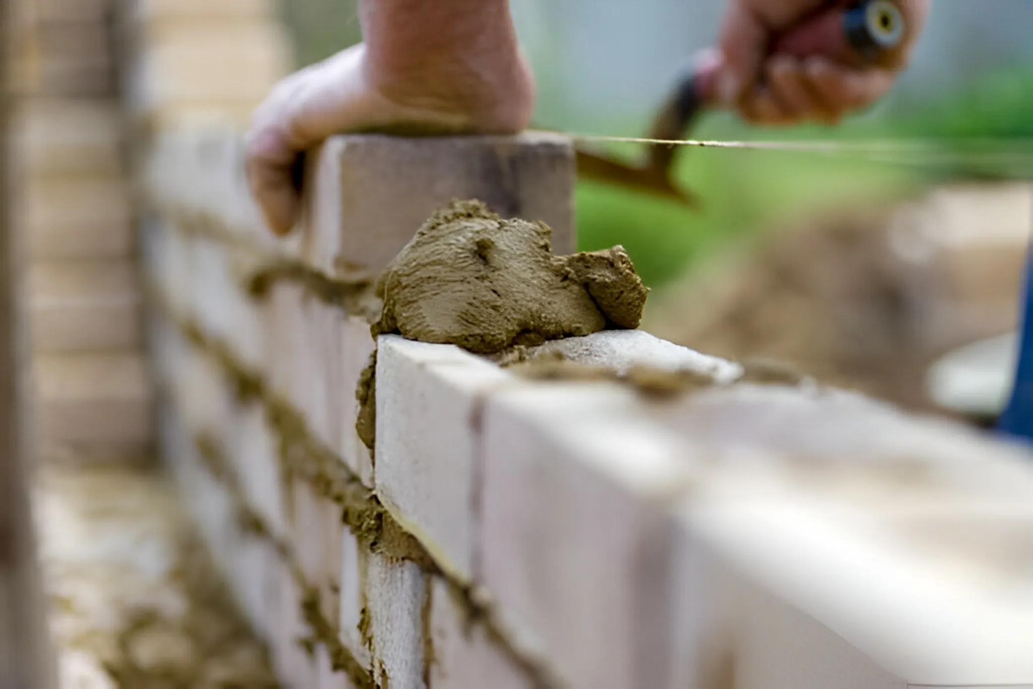 Hardscaping contractor applying mortar during a paver installation project in Mansfield, TX