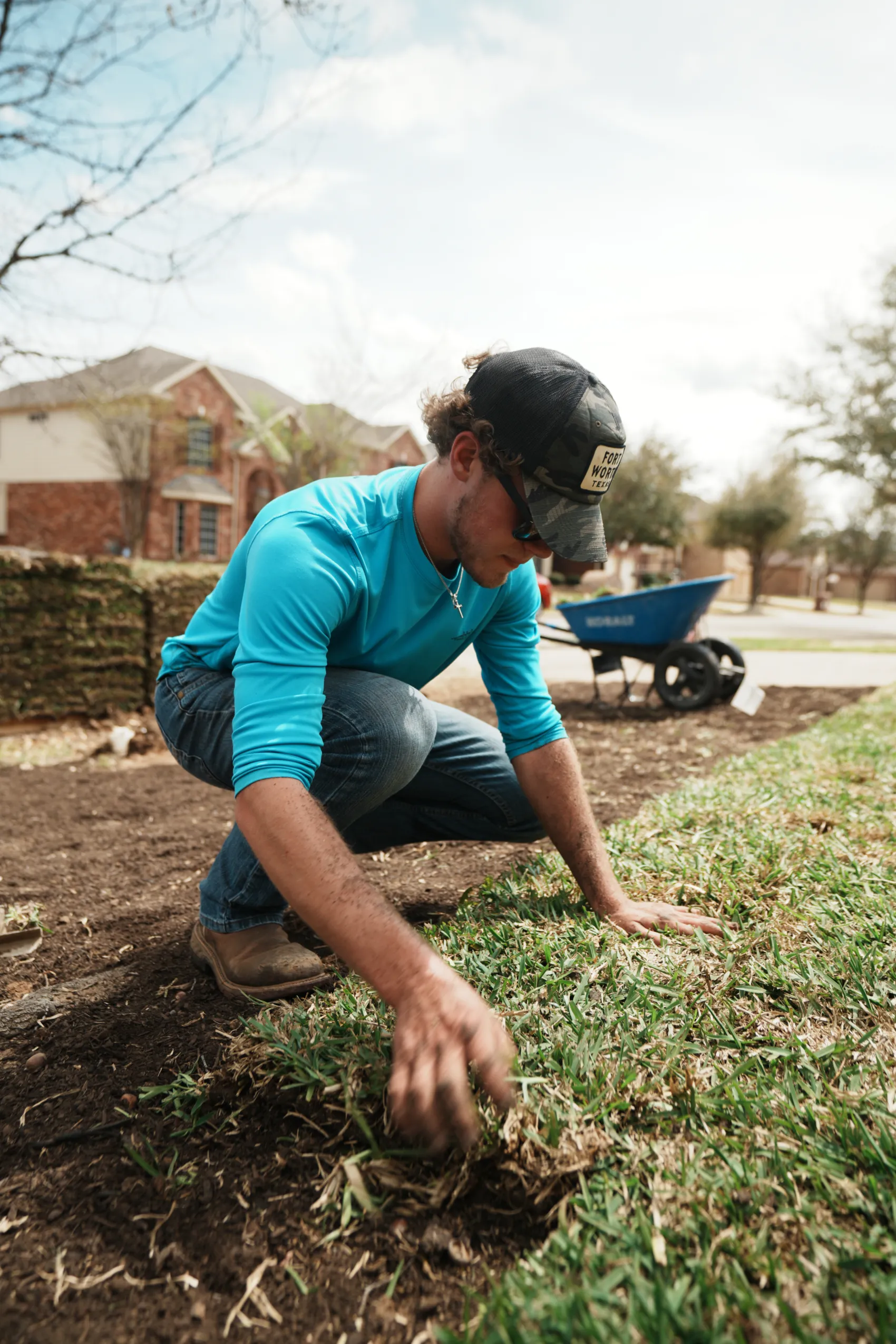 Sod installer in Mansfield, TX laying fresh sod by hand for a new lawn