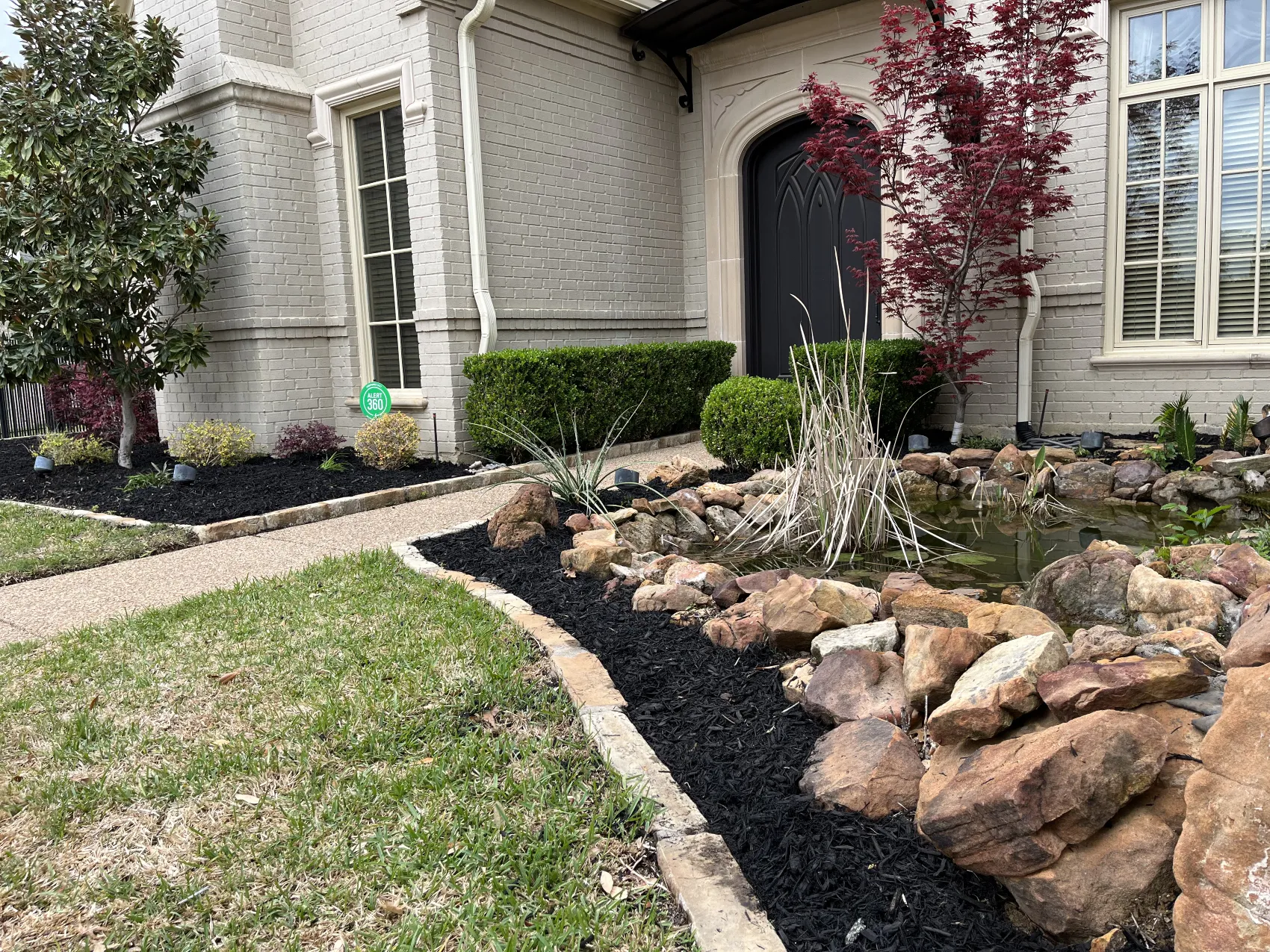 Landscaping project in Mansfield, TX featuring a stone accented front yard design