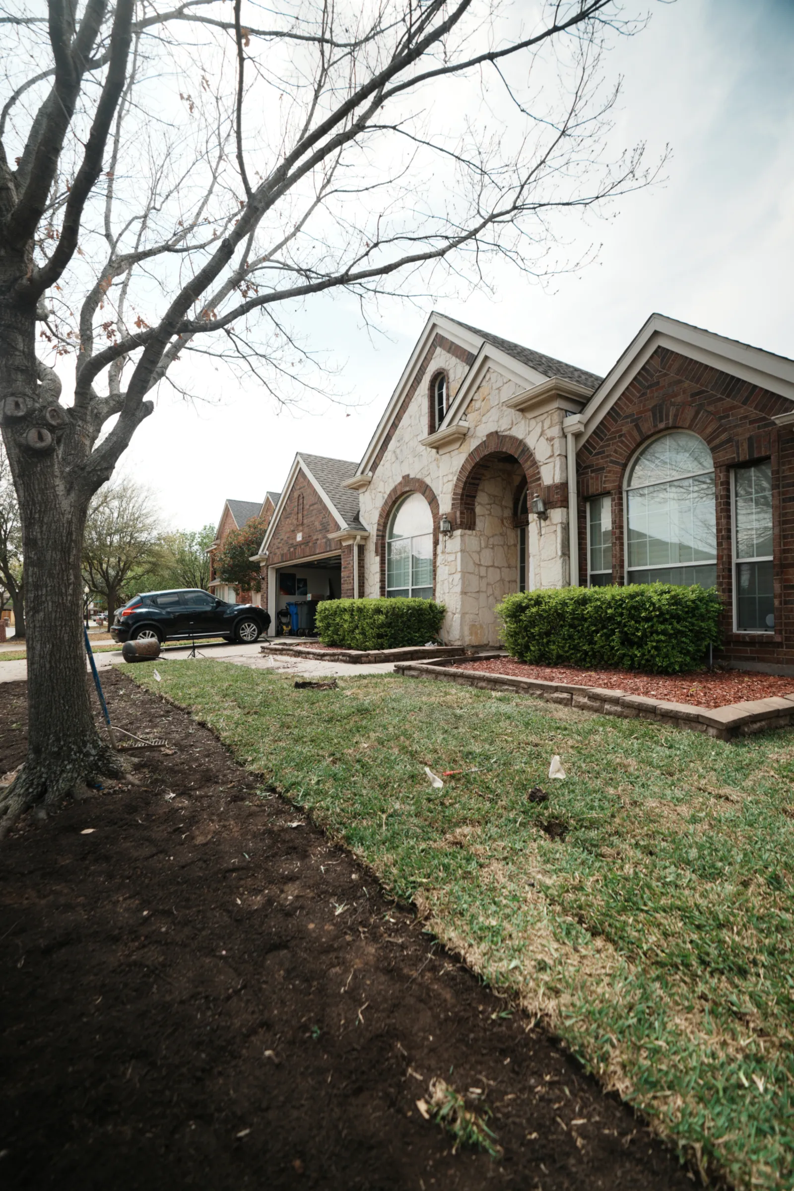 Landscaping project in Mansfield, TX with trimmed shrubs and fresh mulch beds