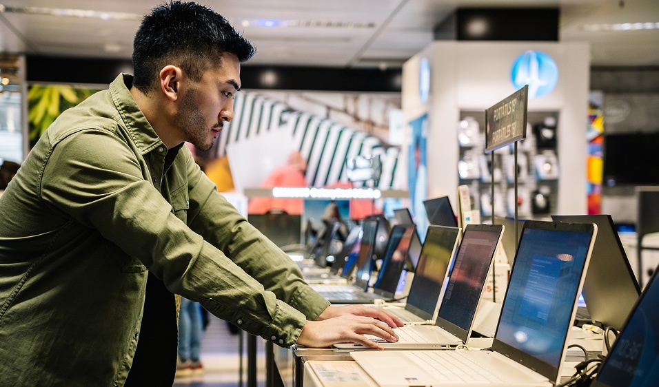 Tech user focusing on benchmark results on screen in a shop