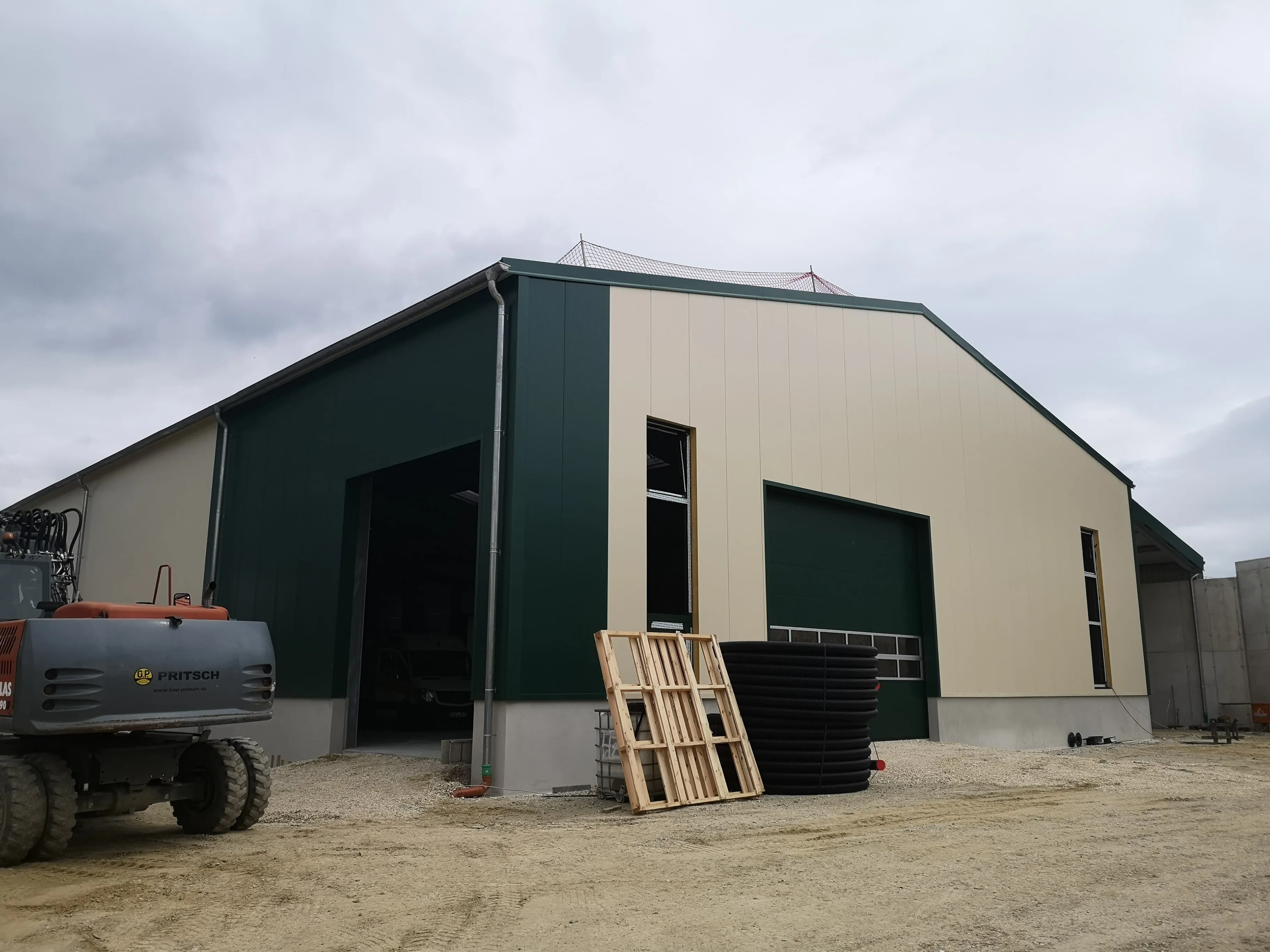 Gewerbehalle mit grüner Fassadenverkleidung
