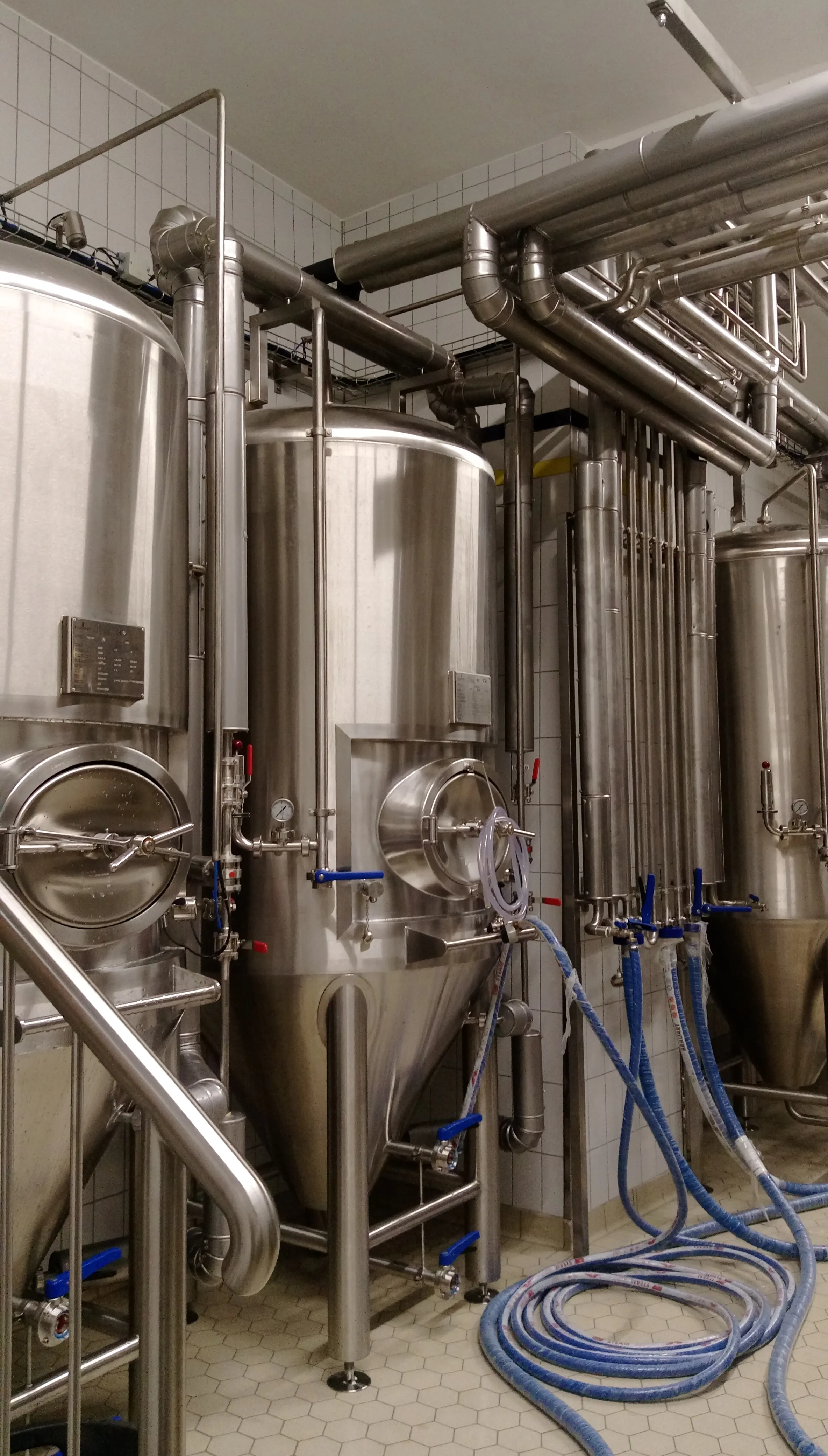 Produktionsraum mit Edelstahltanks und Rohrleitungen
