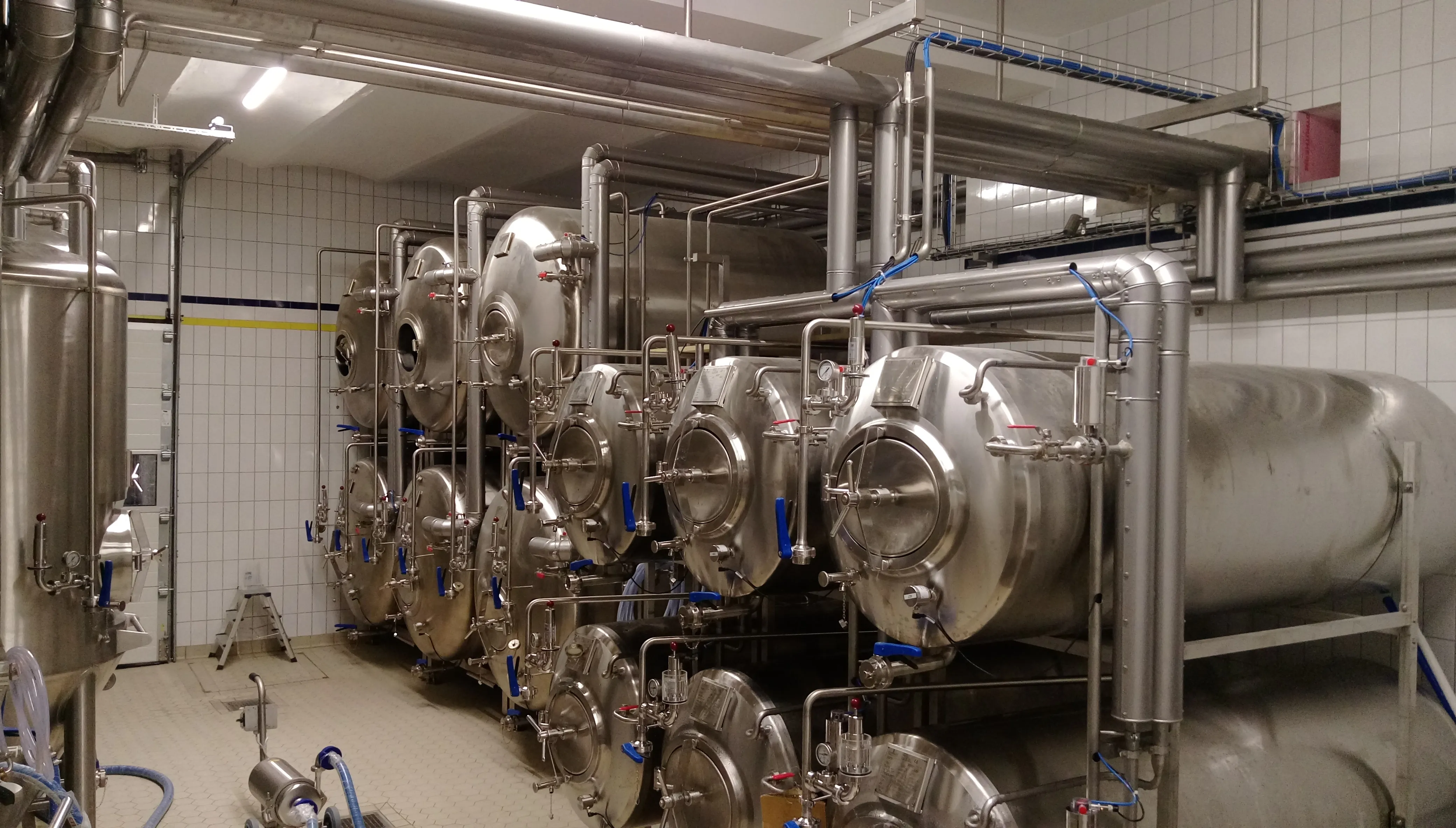 Produktionsraum mit Edelstahltanks und Rohrleitungen
