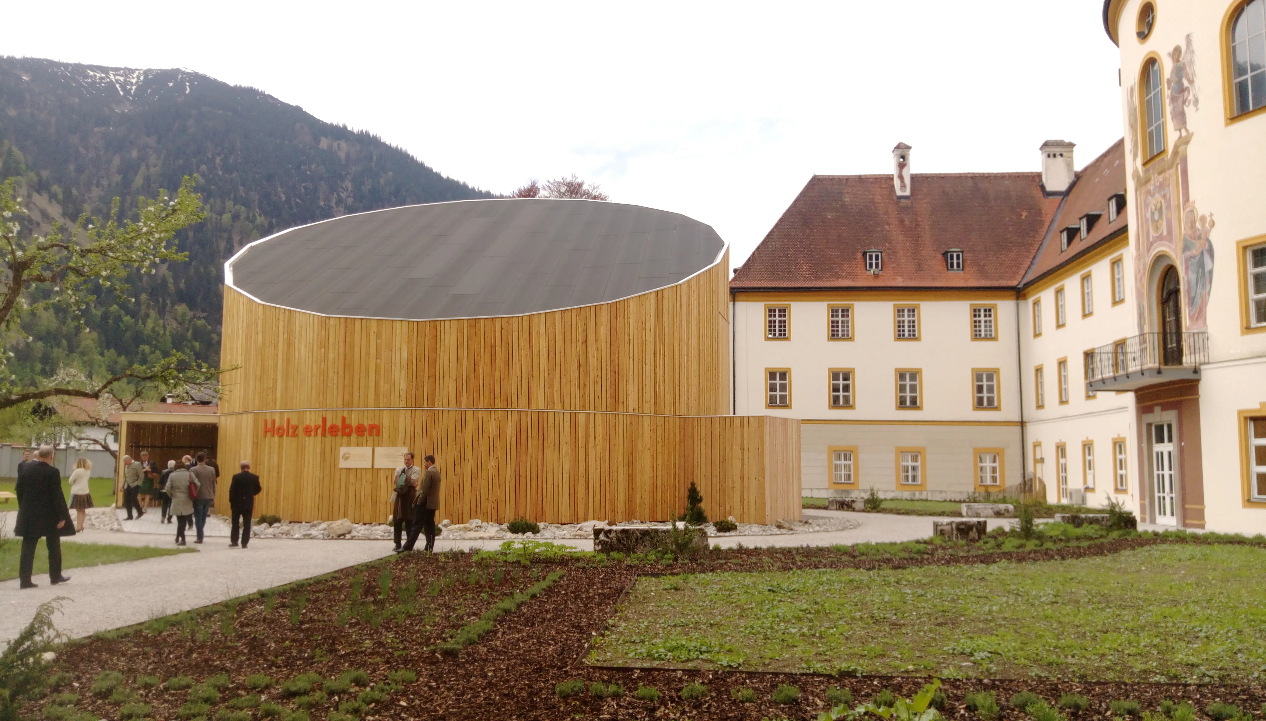 Runder Holzbau an einem historischen Bestandsgebäude
