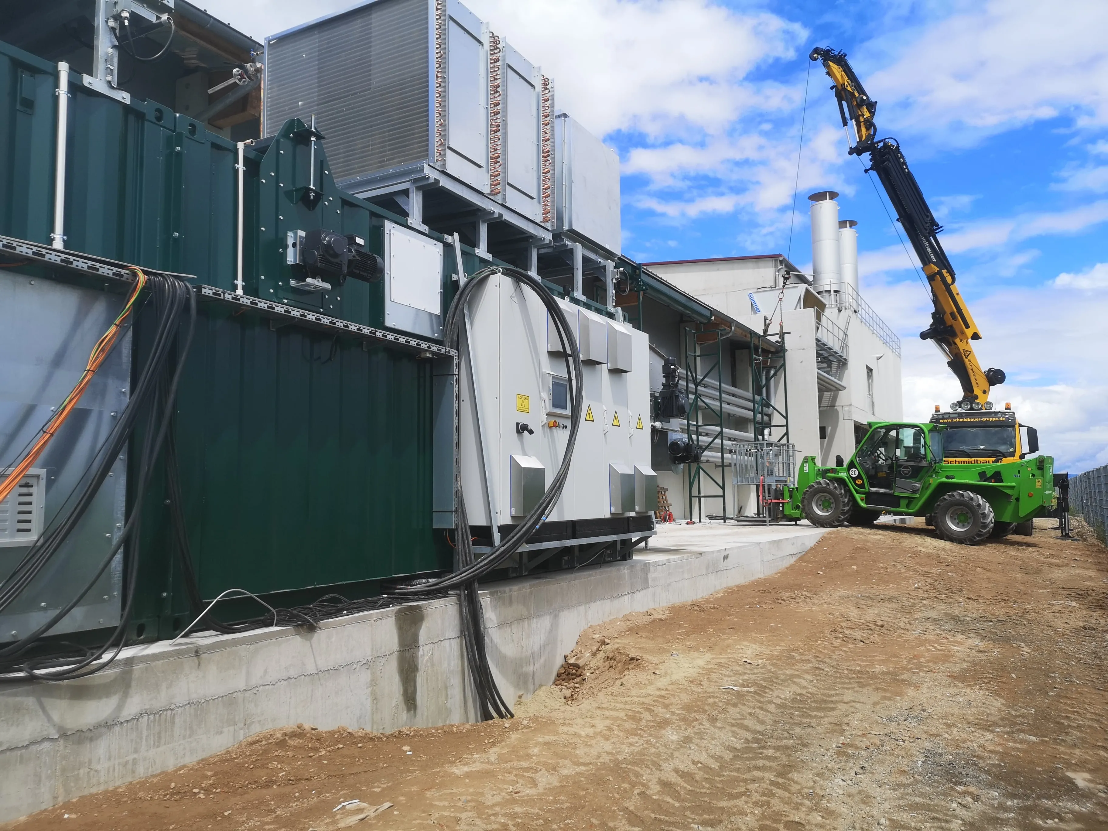 Montage technischer Anlagen an einem Industriebau mit Kran