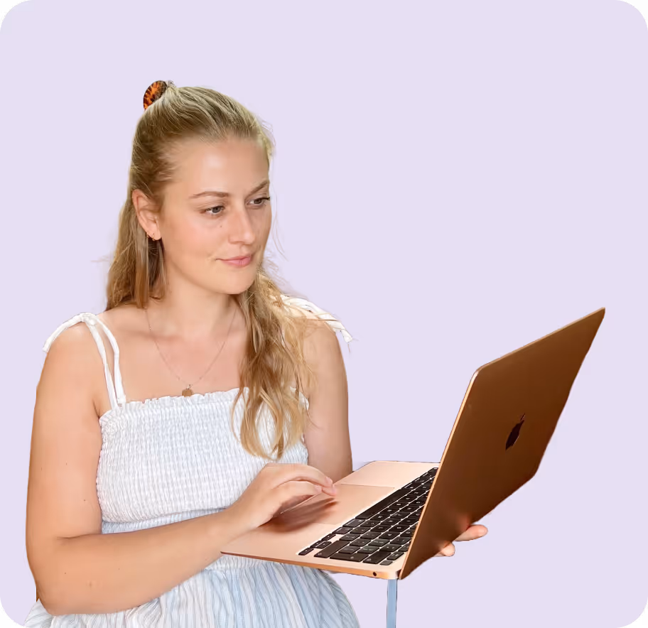 Rachel, freelance web designer, holding her laptop and looking at the laptop screen.