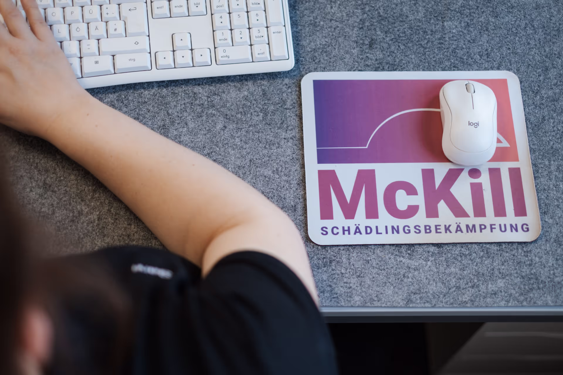 Ein McKill Mitarbeiter am Schreibtisch am arbeiten mit Fokus auf das McKill Mousepad