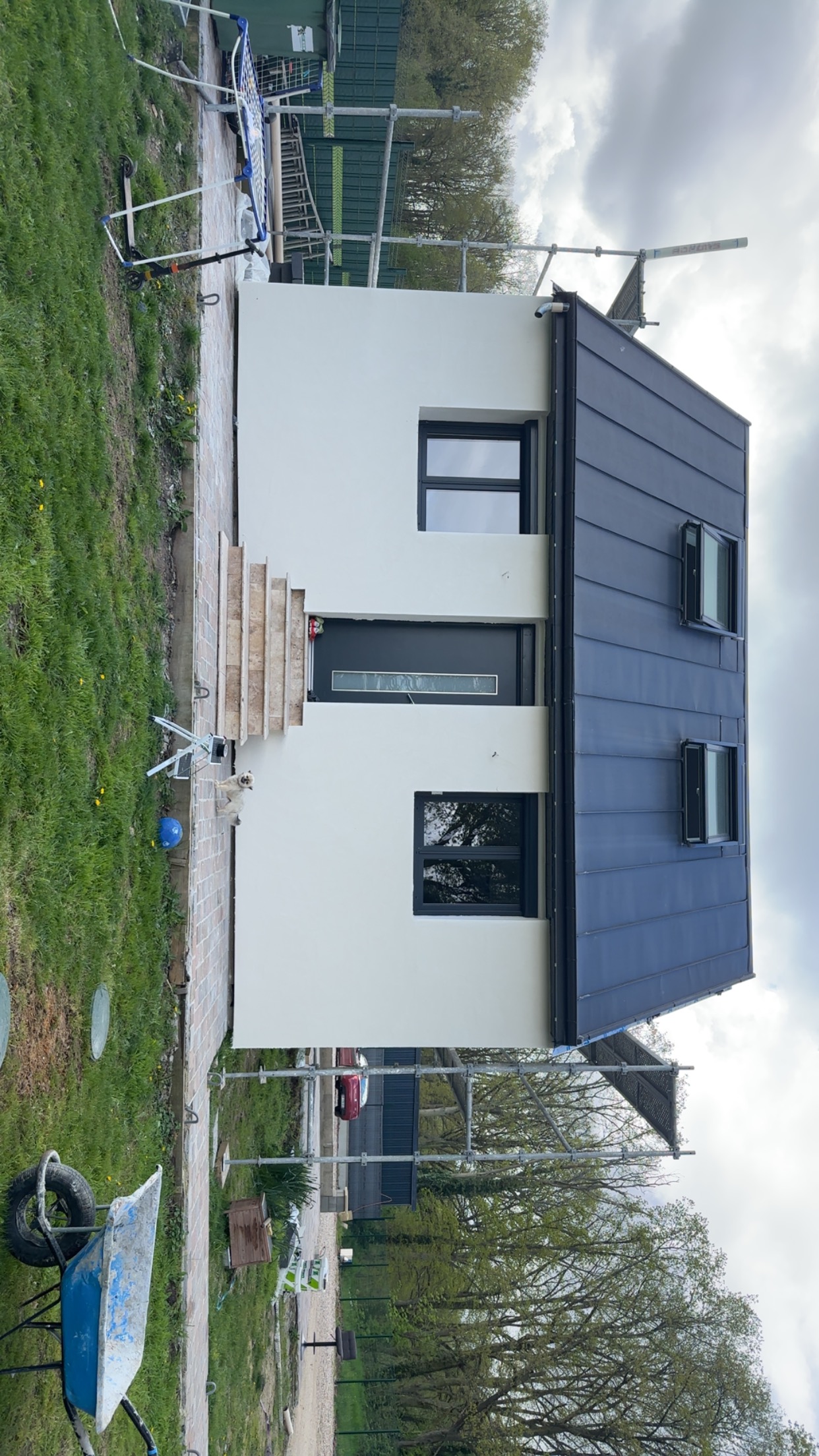 Maison blanche moderne avec toit zinc noir, échafaudage 