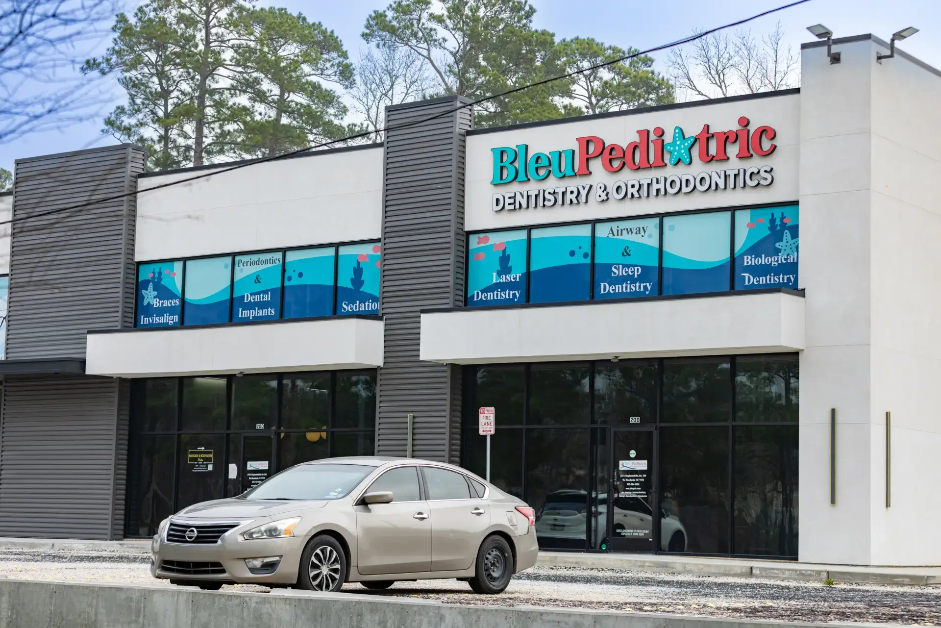 Exterior view of Bleu Pediatric Dentistry & Orthodontics office with a beige car parked in front.