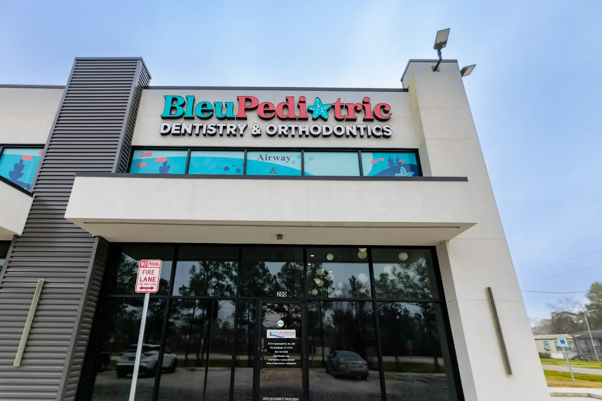 Entrance of Bleu Pediatric Dentistry & Orthodontics with large glass doors and colorful signage.
