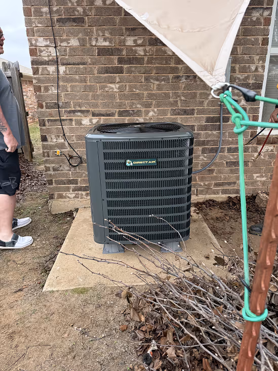 Person adjusting air conditioning unit near window with indoor plant