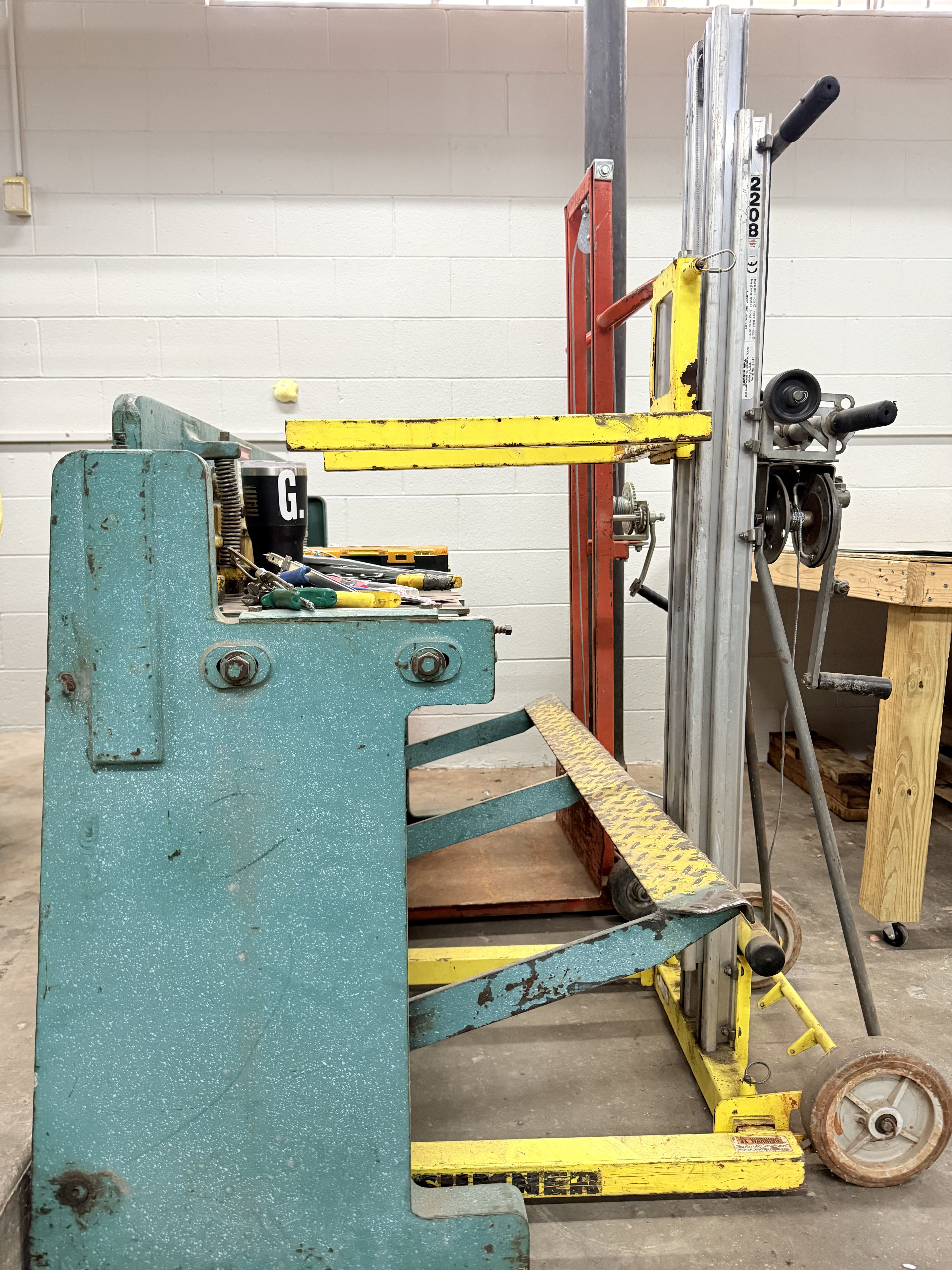 Industrial workshop with yellow forklift and teal machinery