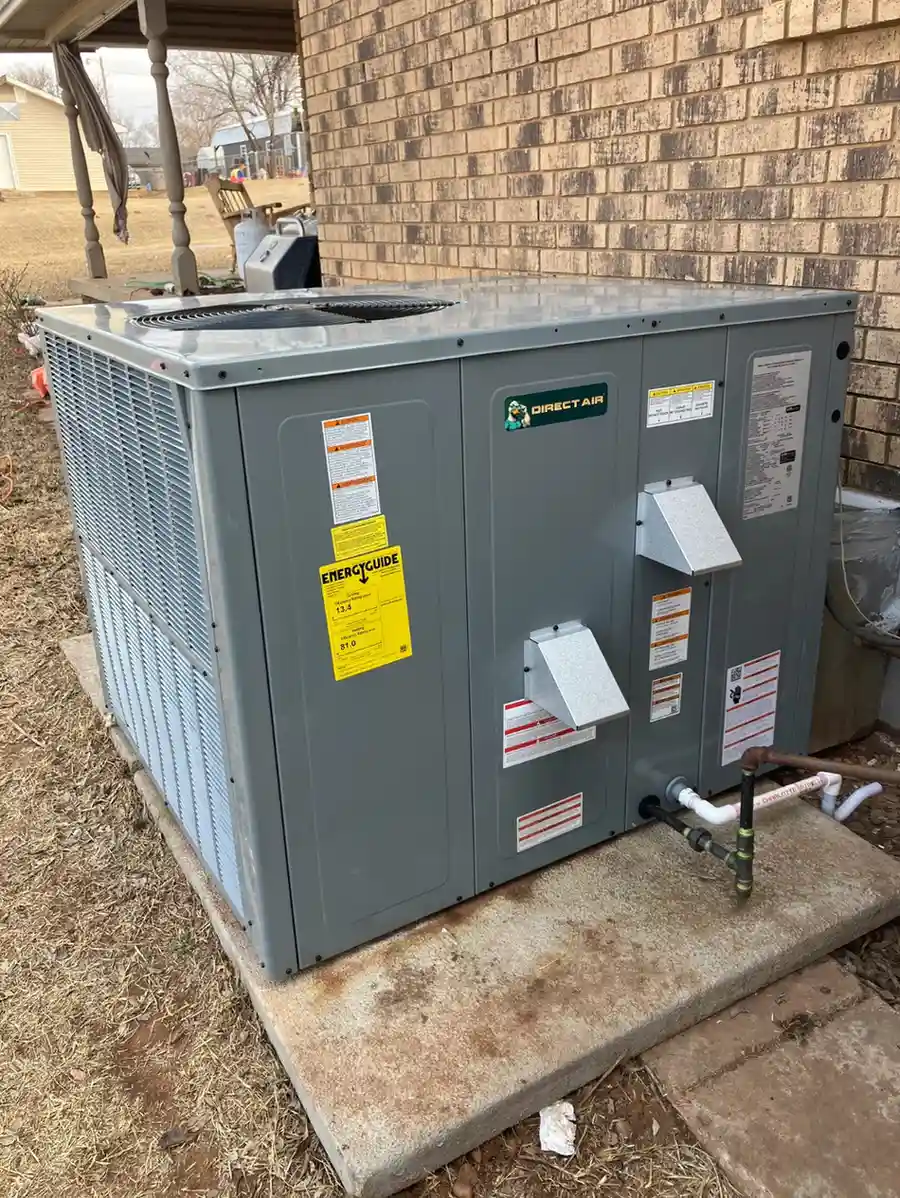 Gray Direct Air HVAC unit installed beside brick house exterior