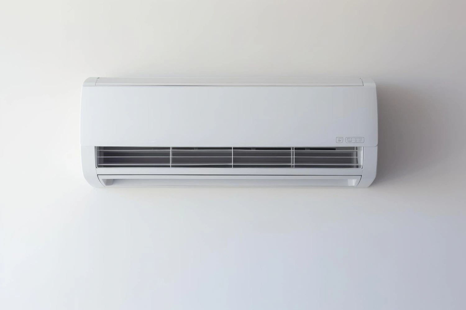 White wall-mounted air conditioning unit with ventilation grille