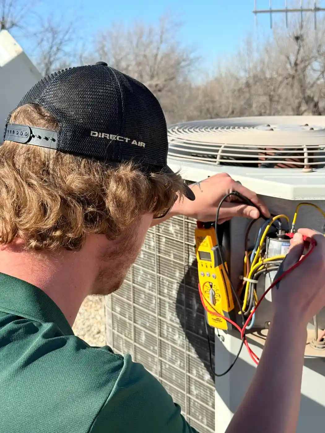Technician checking HVAC unit with yellow diagnostic meter outdoors