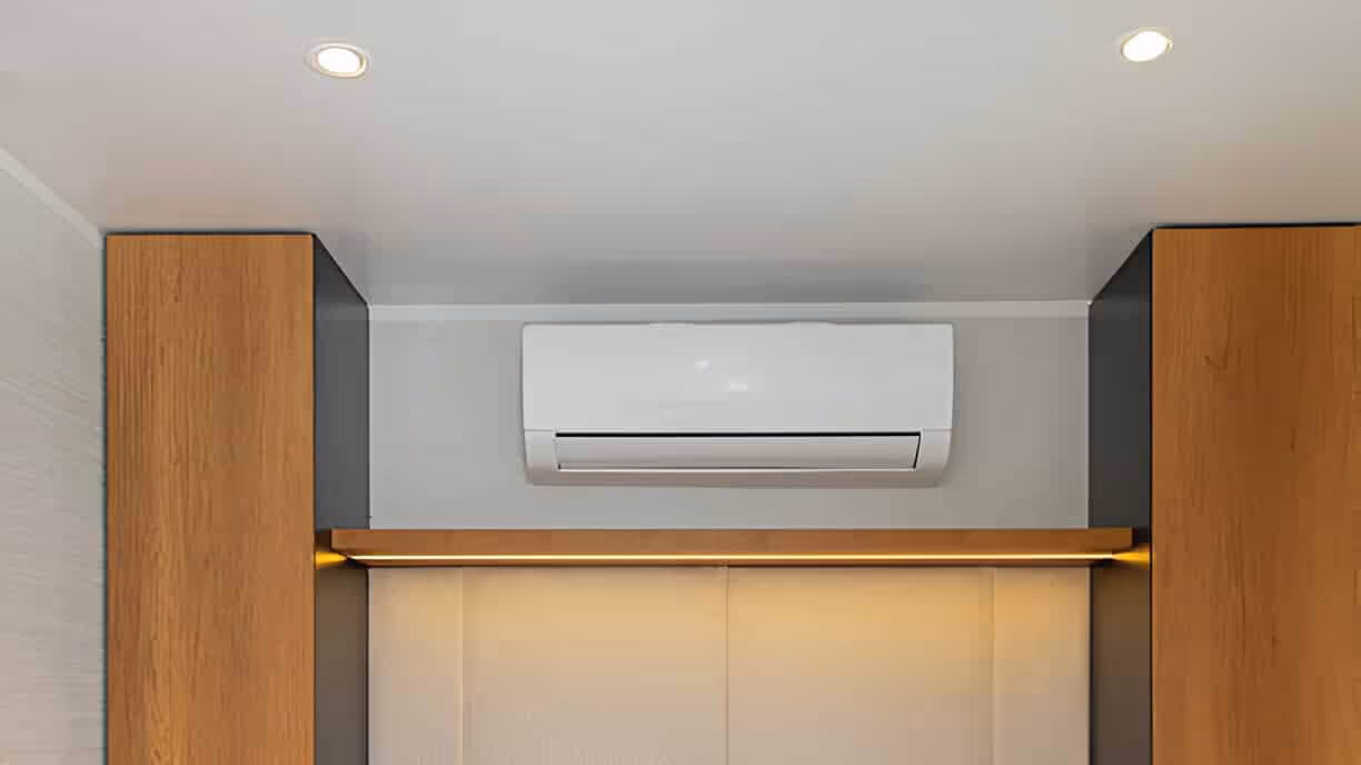 Wall-mounted air conditioner between wooden panels with recessed lighting
