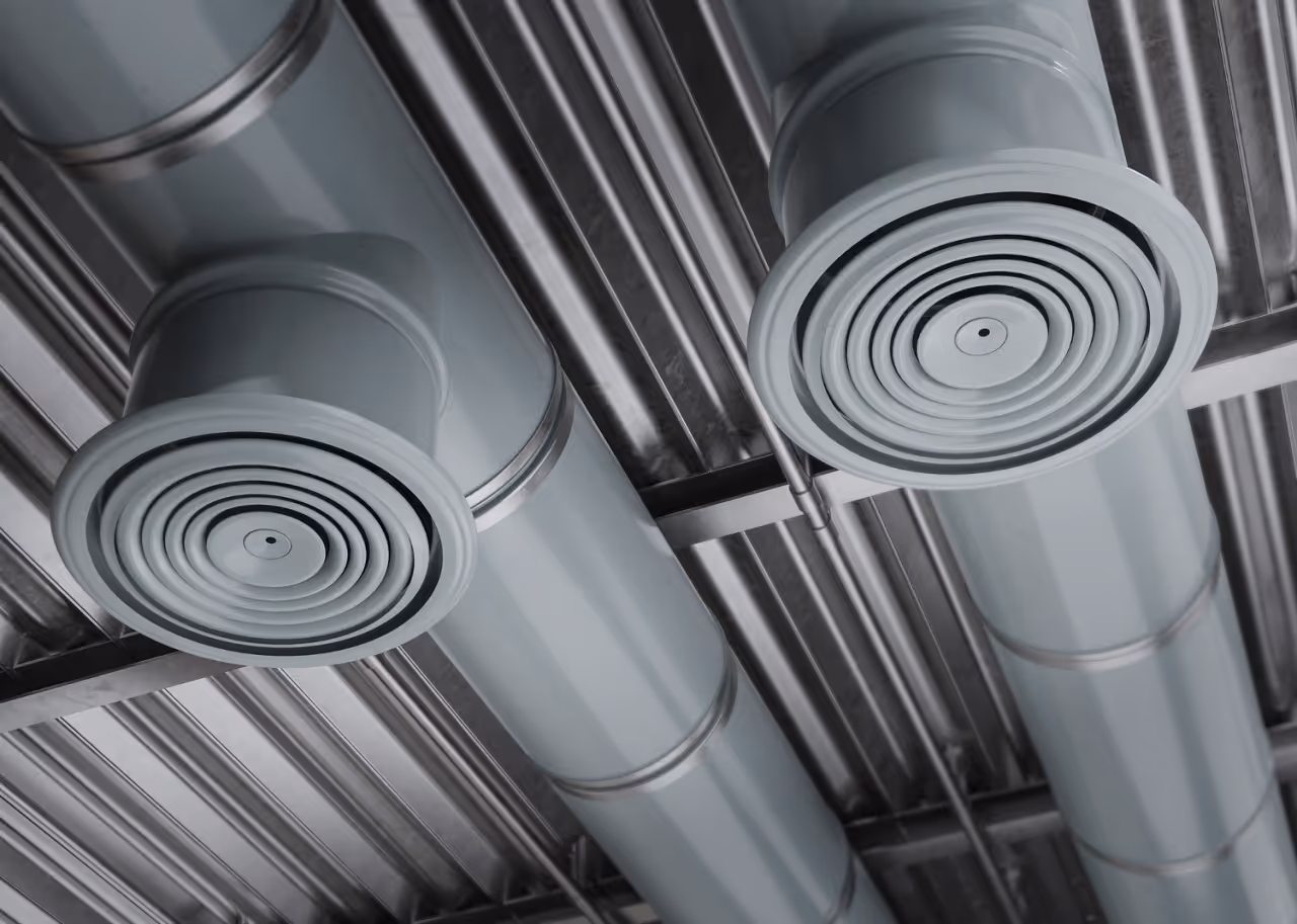 Industrial ventilation ducts with circular vents in monochrome gray