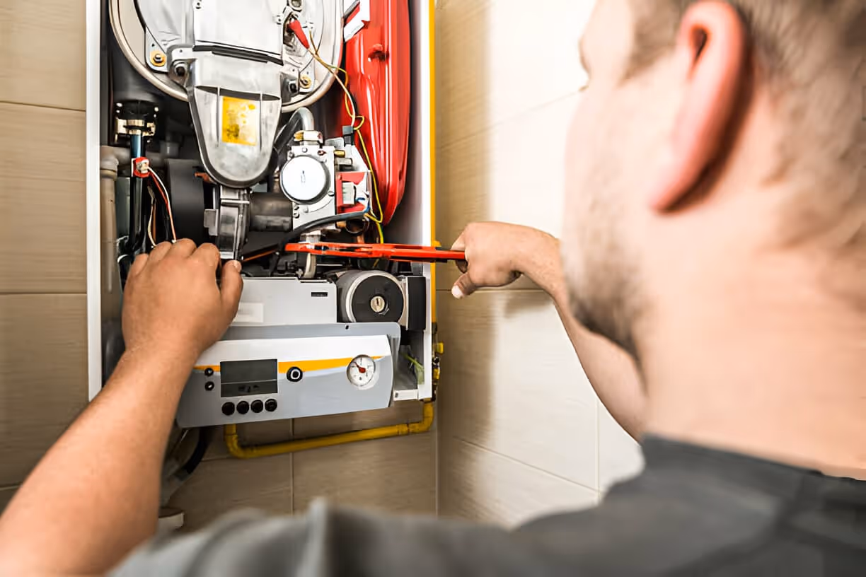 Technician repairing internal components of a heating or boiler system