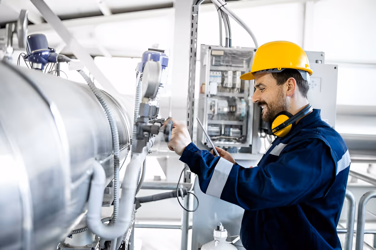 Industrial technician checking machinery in manufacturing facility