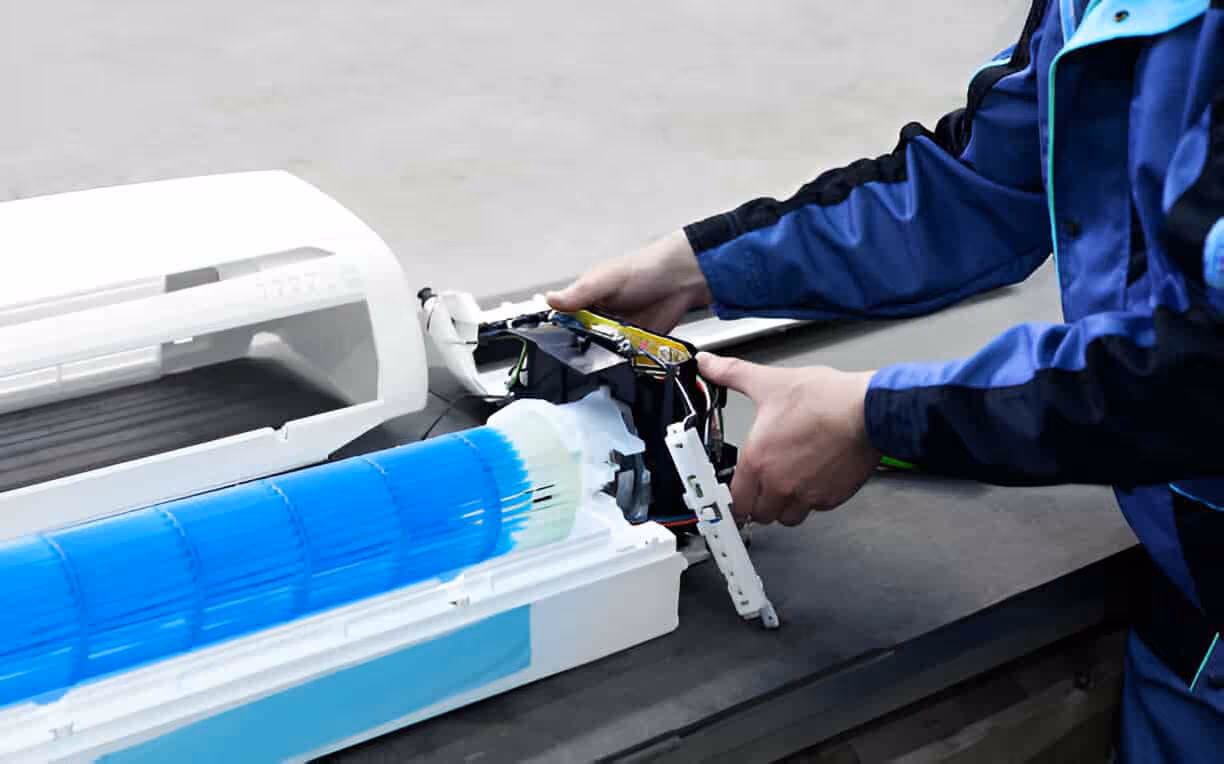 Technician repairing printer with blue and white components visible