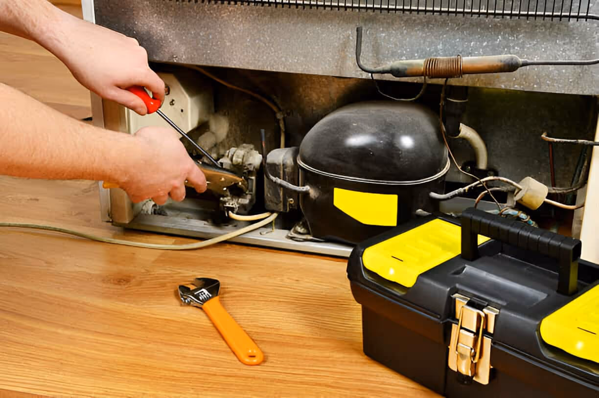Repairing appliance with screwdriver, tools, and electrical components