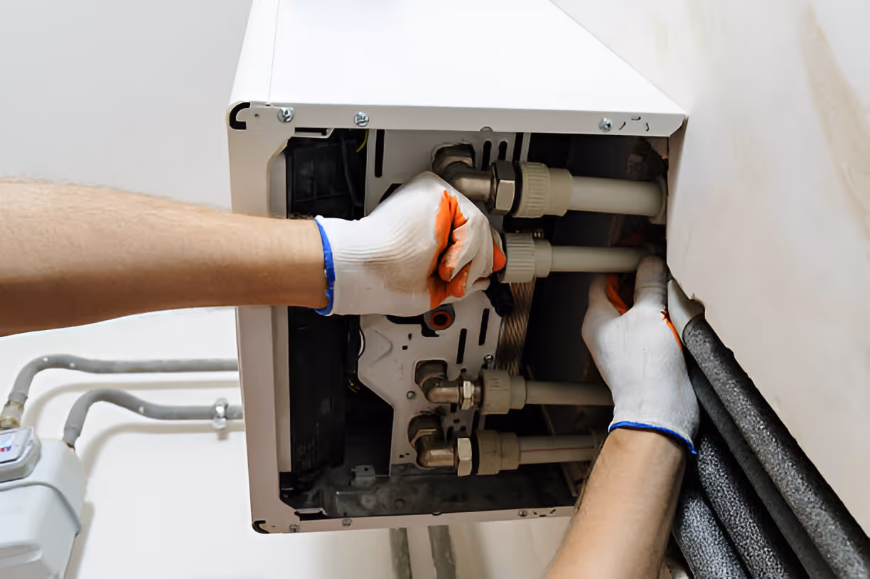 Technician repairing internal components of a white electrical or plumbing system