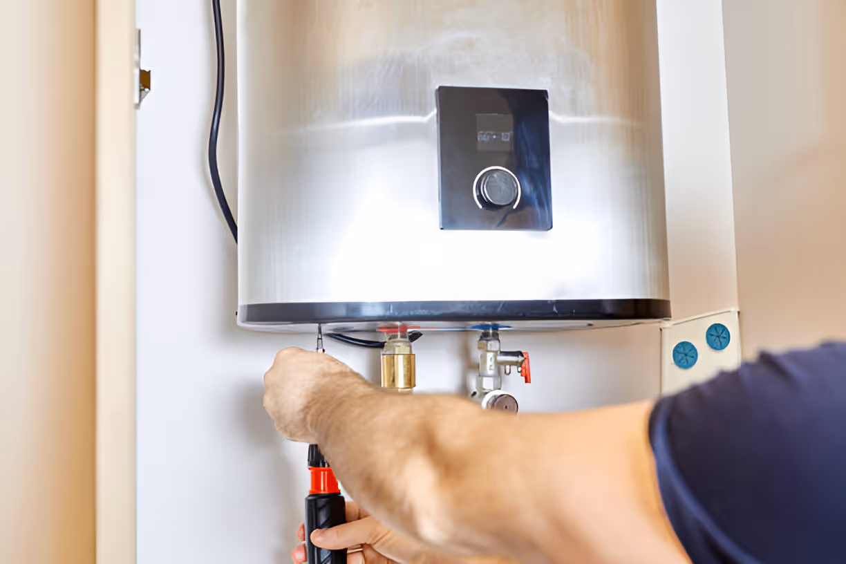 Technician repairing an electric water heater with tools