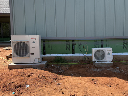 Technician checking air conditioning unit with pressure gauges