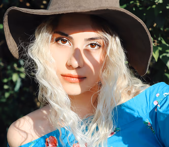 Portrait of a stylish woman with long blonde hair and wide-brim hat, symbolizing authentic personal branding on Instagram.