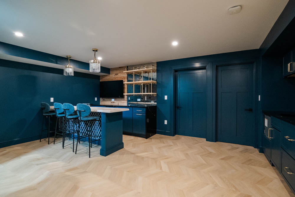 Custom live edge wood bar with tv, shelves, mirror backing, tile wall, and seating in basement remodel by JW Design | Build