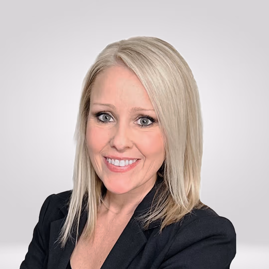 Smiling woman with shoulder-length blonde hair wearing a black blazer against a light gray background.