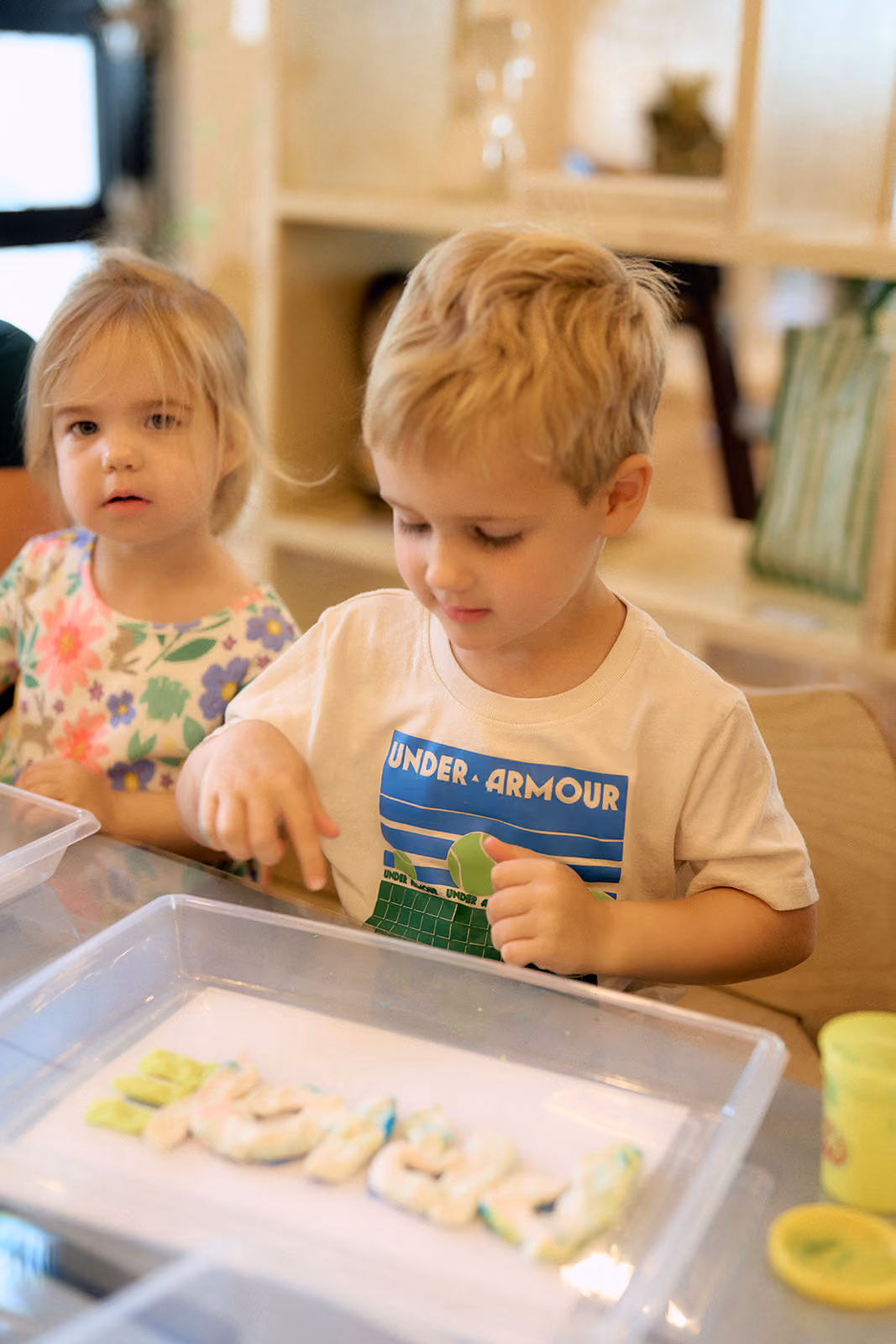 Two campers making letters out of play dough