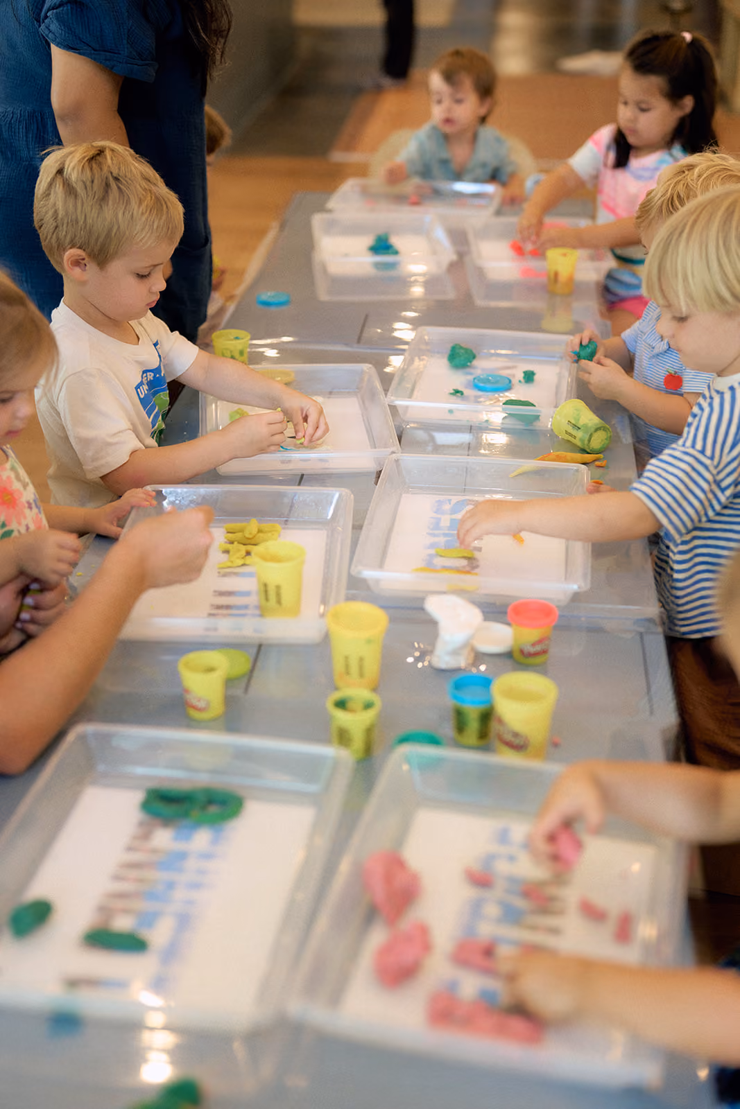 A table of campers working on play dough letter mats
