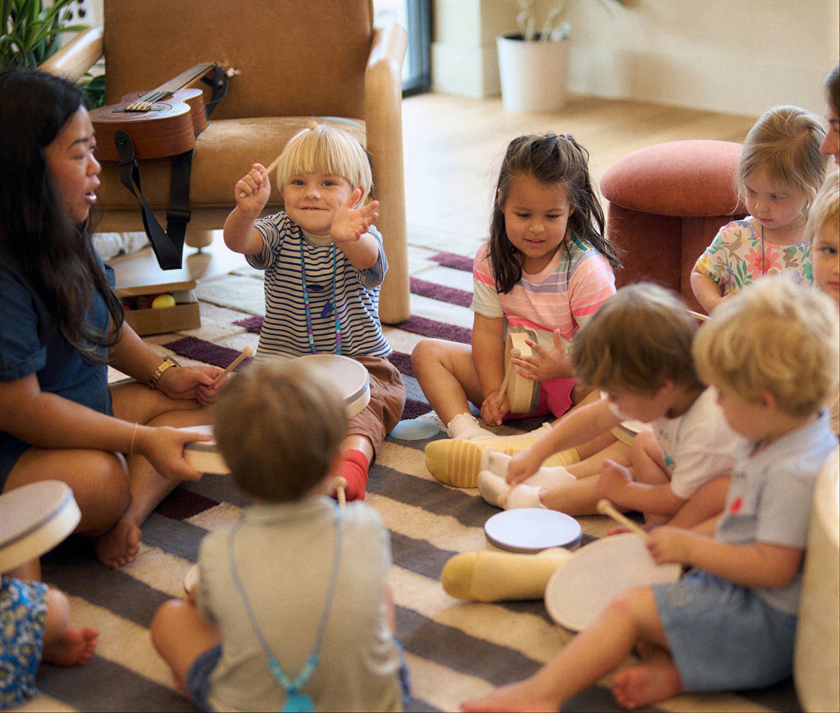 Children making music in a circle with a Kinry teacher