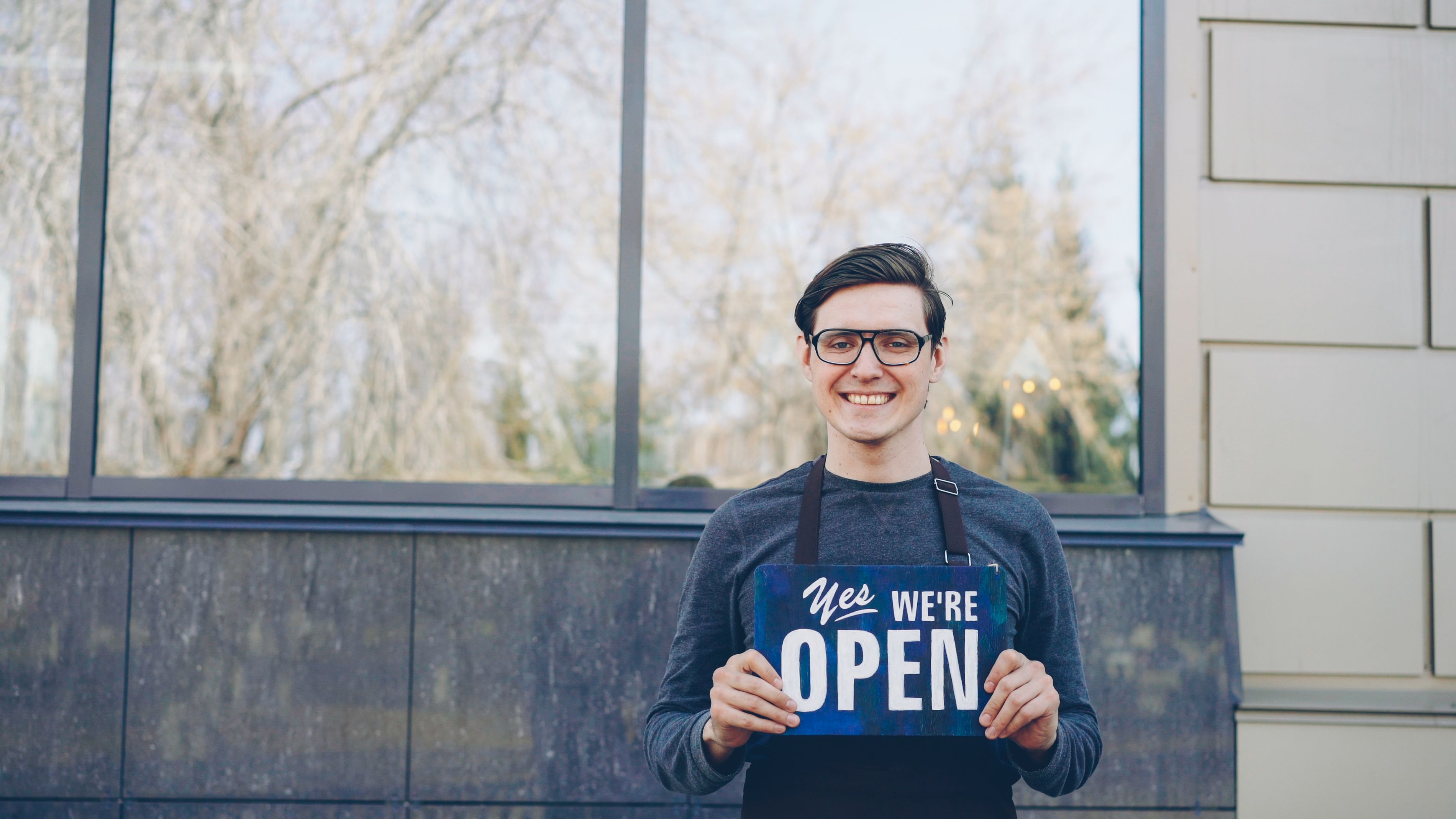 Smiling small business owner outside their storefront