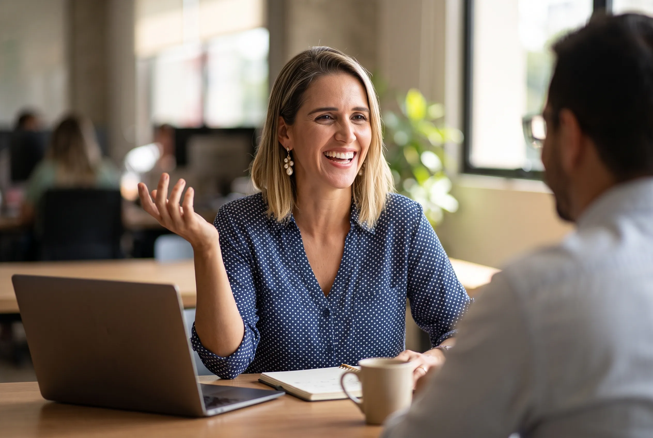 Small business owner working at a desk with a laptop in natural light