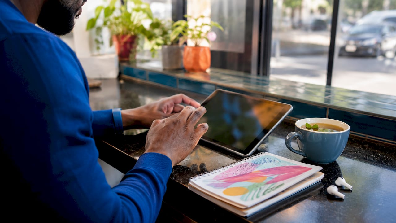 Hands using tablet in coffee shop for loan application