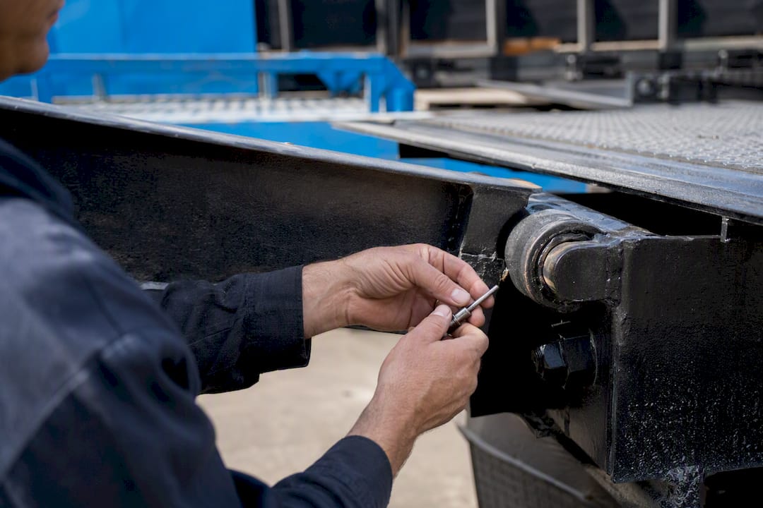 Hands inspecting logistics equipment in warehouse