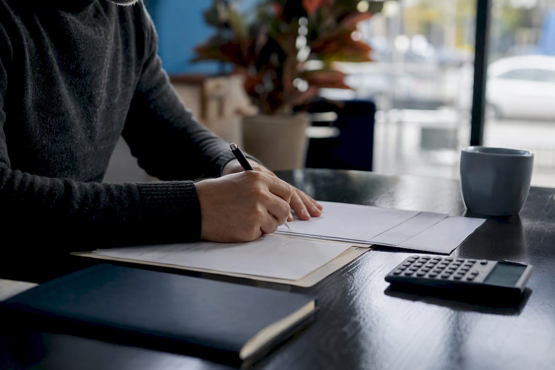 Hands filling out loan closing forms