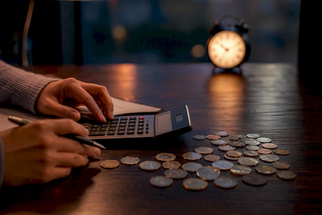 Coins and calculator on table representing fees