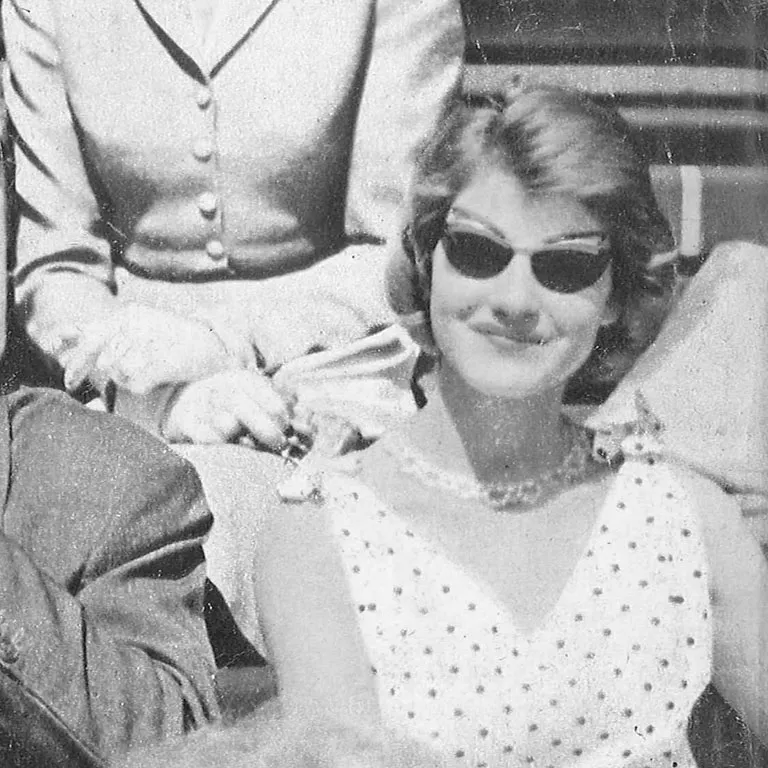 Detail from a Solamor advertisement showing a smiling woman with a vintage look, wearing a white polka-dot dress and retro-style Solamor sunglasses.